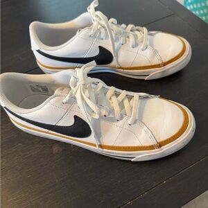 Nike White Low-Top Sneakers with Black Swoosh and Gold Accent